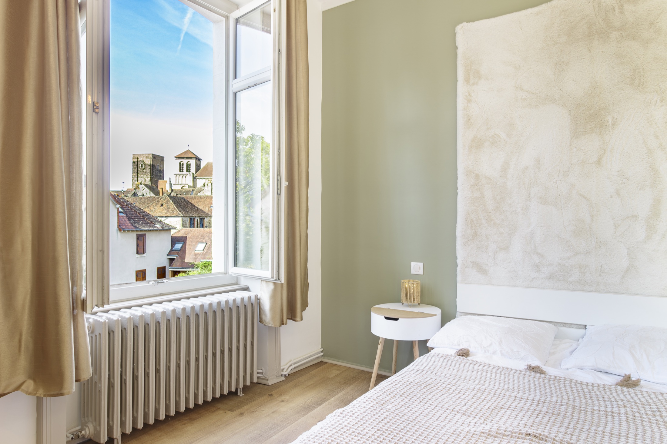Chambre lumineuse avec vue sur les toits